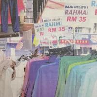 Seorang pemuda memilih baju Melayu yang ditawarkan pada harga RM35 sehelai di kedai Toko Ar-Rayyan di Kompleks Tok Arau, Arau.